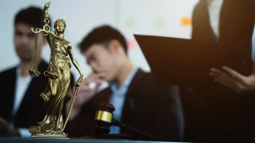 A group of attorneys and a justice symbol on the table