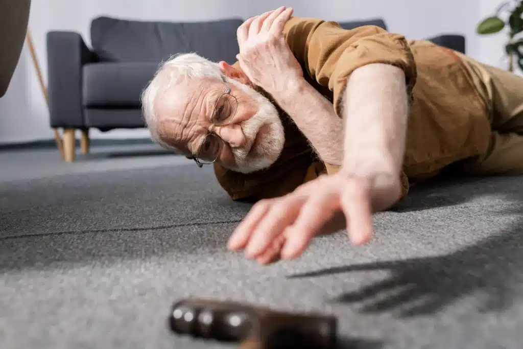 An elderly man fell and trying to reach for his cane