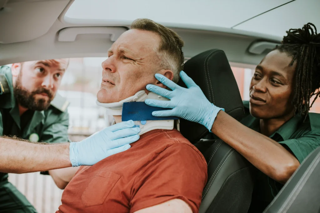 Two nurses helping a man with fix his neck