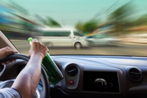 driver speeding through intersection with beer in hand 