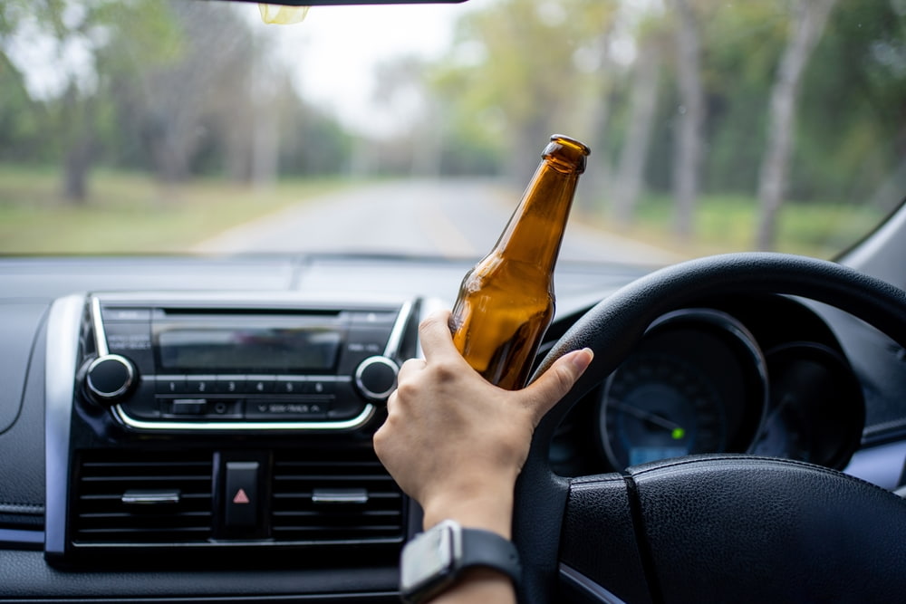 Driver holding a beer while driving