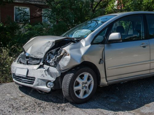 A grey car with damaged parts after a defectice car parts accident.