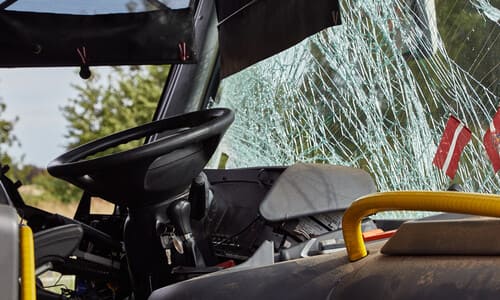 The interior of a bus with a broken windshield after an accident on the road.