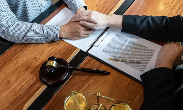 A medical malpractice lawyer holding a client's hand assuring him that they will make a fair claim.