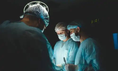 A group of medical staff gathered around an operating table in an emergency room.