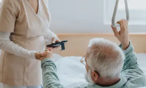 A senior citizen in a nursing home asking for help up from his bed because of bed sores.