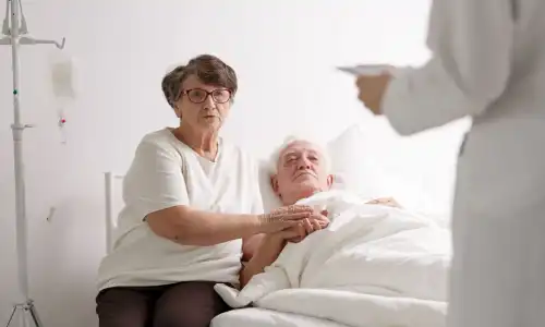 An old man and his wife in a hospital consulting with a doctor after he choked in a nursing home.