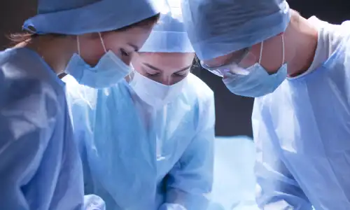 A team of surgeons gathered around an operating table in a hospital.