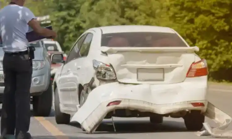 A driver looking through his car's papers after an accident with another vehicle.