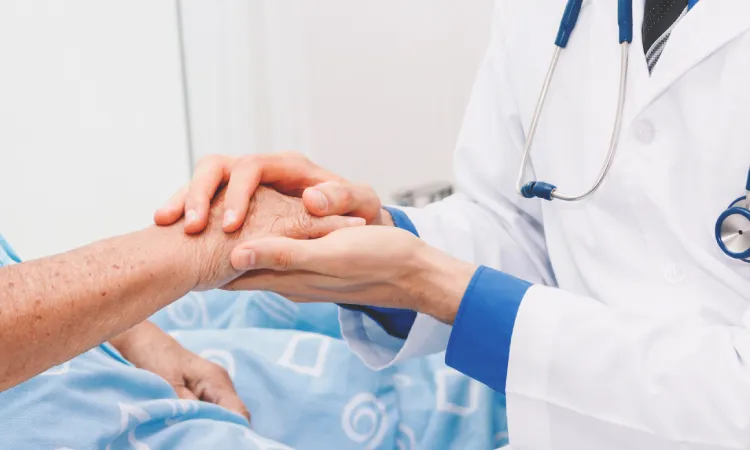 A doctor holding the hand of an elderly patient as she tries to comfort her after nursing home abuse.