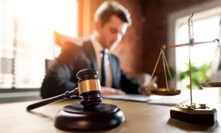 A personal injury lawyer studying documents at his desk for a client's case.