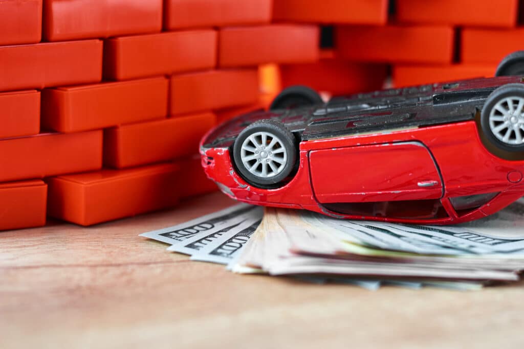 life insurance in car accident concept. Broken car and dollar banknotes