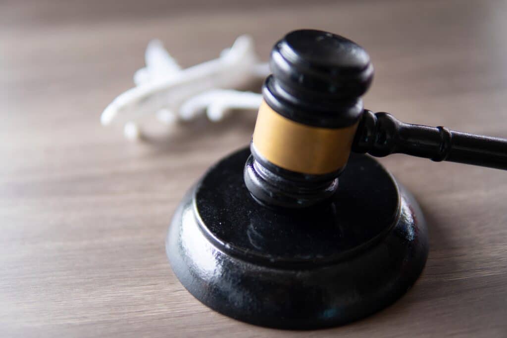 A judge gavel and toy plane on table. Aviation law concept.