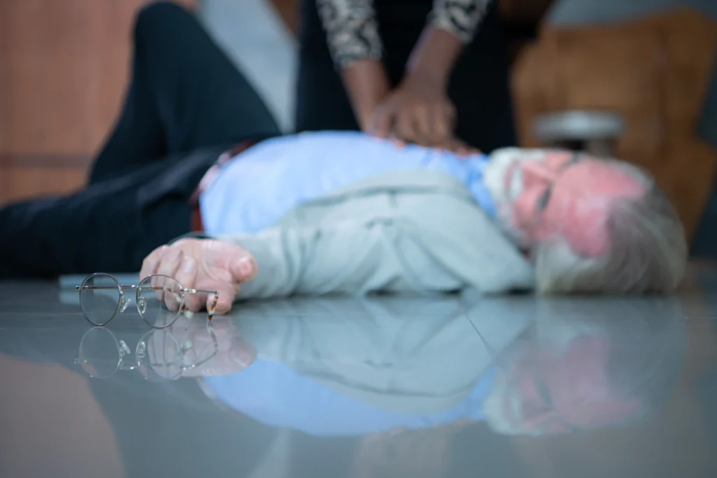 A lady pumping the heart of a elderly man that collapse