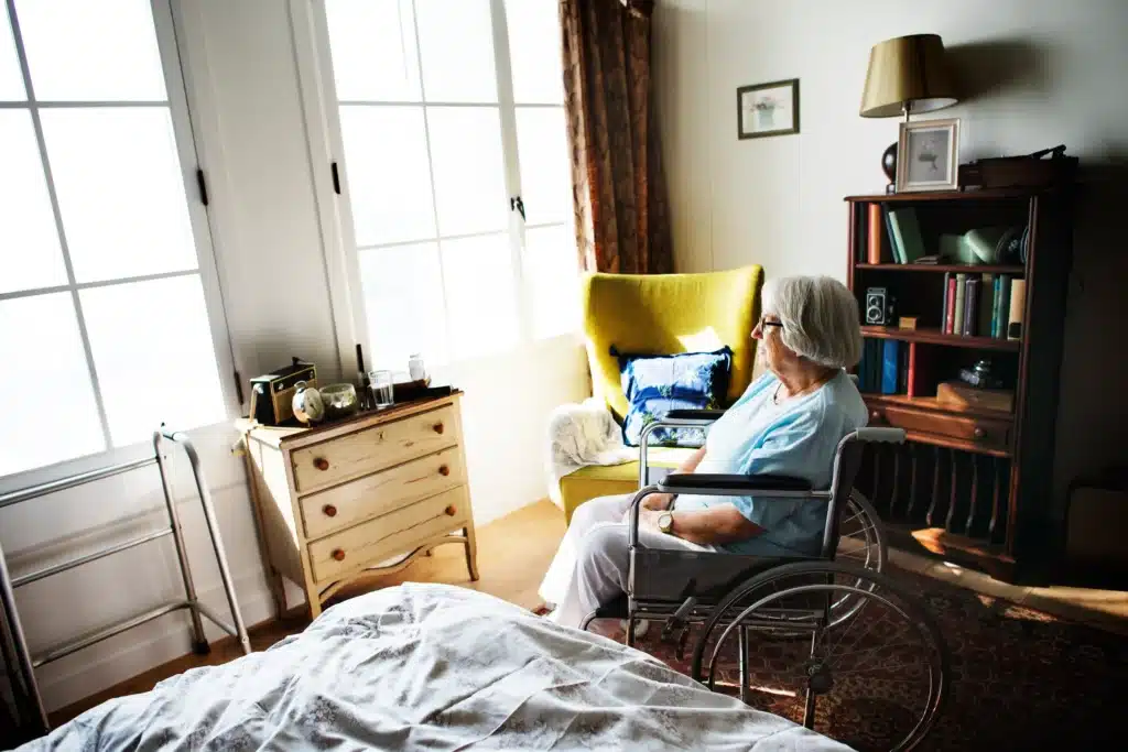 An elderly woman sitting alone in her room