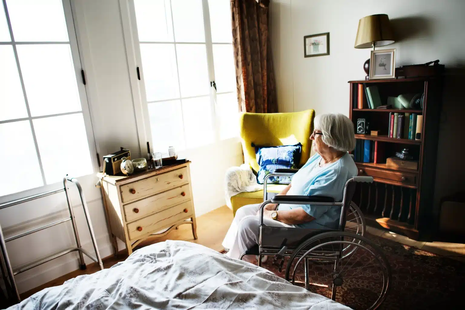 An elderly woman sitting alone in her room