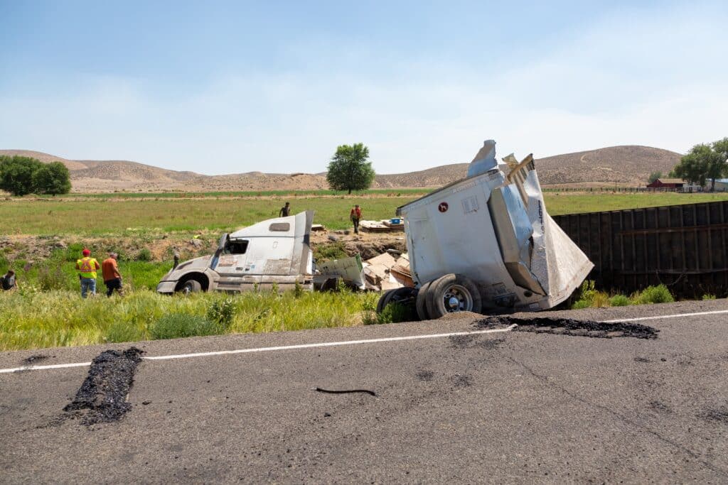 An accident truck and people around the woods it feel in