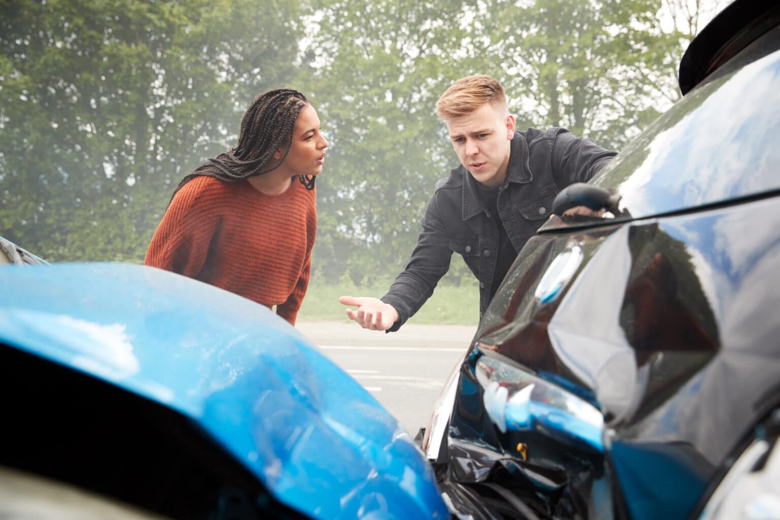 two angry motorists arguing over responsibility for car accidents