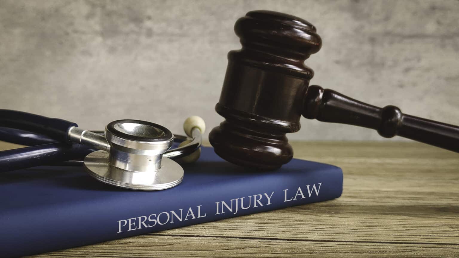 Gavel and stethoscope on a book titled "PERSONAL INJURY LAW," symbolizing legal action for medical issues.