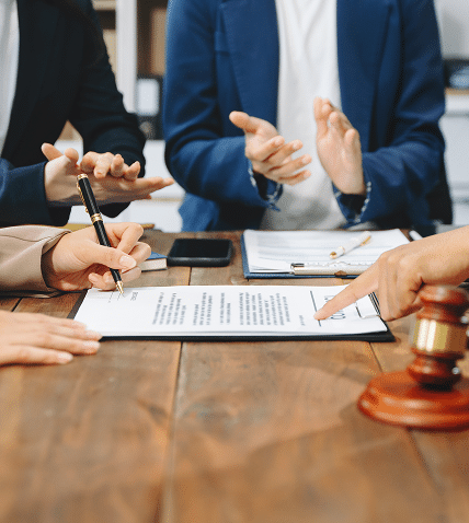 legal professionals discussing documents during a meeting with a judge's gavel on the table