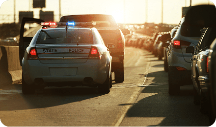 state police car with flashing lights in heavy traffic on a highway