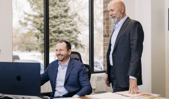 attorney sean olson and chief operating officer rob buick looking at a clients file together