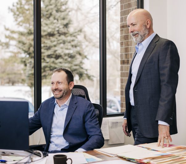 attorney sean olson and chief operating officer rob buick looking at a clients file together