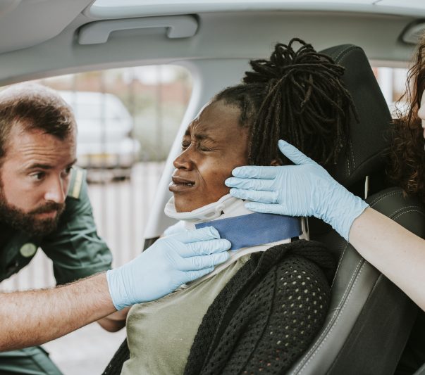 Paramedic placing a cervical collar to an injured woman from car accident