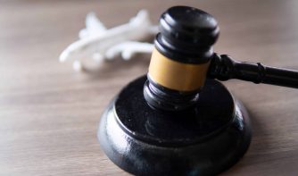 A judge gavel and toy plane on table. Aviation law concept.