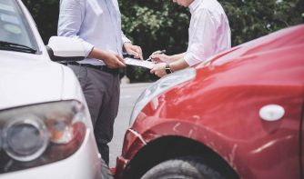 Insurance Agent examine Damaged Car and customer filing signature on Report Claim Form process after accident, Traffic Accident and insurance concept.