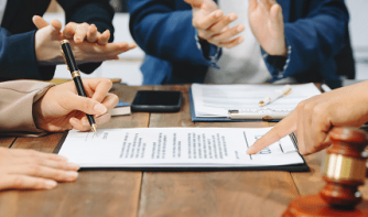 legal professionals discussing documents during a meeting with a judge's gavel on the table