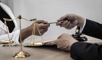 attorney handling client a pen to sign a document