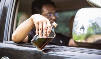drunk driver holding a bottle of whiskey