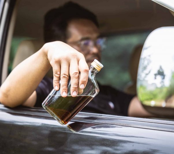 drunk driver holding a bottle of whiskey