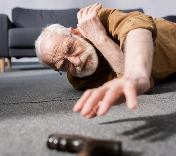 An elderly man fell and trying to reach for his cane