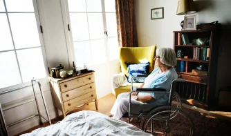 An elderly woman sitting alone in her room