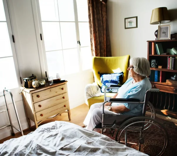 An elderly woman sitting alone in her room