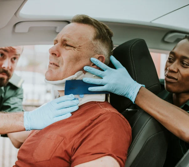 Two nurses helping a man with fix his neck