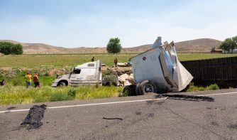 An accident truck and people around the woods it feel in